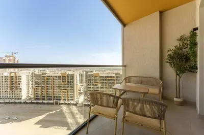 a balcony with two chairs and a table and a view at Daniels 1BR at Waves Grande In Sobha Hartland in Dubai