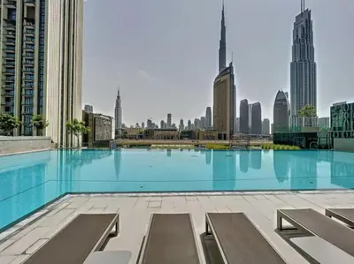 a large swimming pool with a view of a city at Downtown views prime location Dubai mall in Dubai