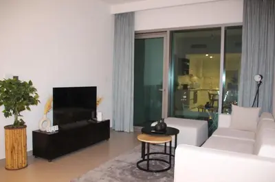 a living room with a white couch and a tv at Downtown views prime location Dubai mall in Dubai