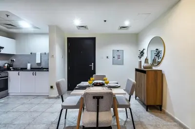 a kitchen and dining room with a table and chairs at Spacious 1-BR Opposite Mall with Huge Pool & Gym in Dubai