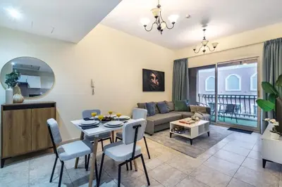 a living room with a couch and a table at Spacious 1-BR Opposite Mall with Huge Pool & Gym in Dubai