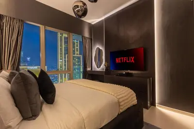 a bedroom with a bed with a tv and a window at Brand New LUXE Downtown Dubai 46th Floor in Dubai
