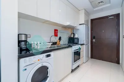 a kitchen with a washer and a washing machine at Bloomfields Stylish Stu in Damac Ghalia in Dubai