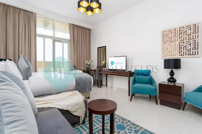 a bedroom with two beds and a desk in it at Bloomfields Stylish Stu in Damac Ghalia in Dubai