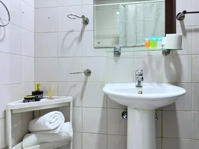 a white bathroom with a sink and a mirror at Stylish Studio with Stunning Marina Canal Views near to the Beach in Dubai