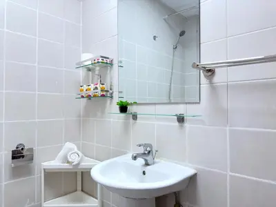 a white bathroom with a sink and a mirror at Stylish Studio with Stunning Marina Canal Views near to the Beach in Dubai