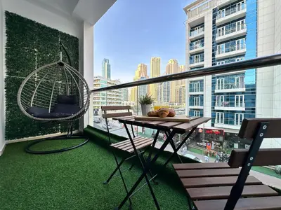 a balcony with a swing and a table and chairs at Stylish Studio with Stunning Marina Canal Views near to the Beach in Dubai