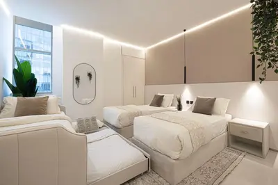 two beds in a white room with at Downtown Views - For Big families & Groups - Up to 13 Guests - 6 min from Burj Khalifa in Dubai