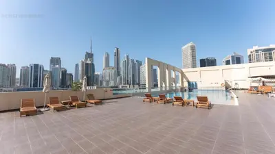 a row of chairs on a rooftop with a city skyline at Great & huge apartment high floor! in Dubai