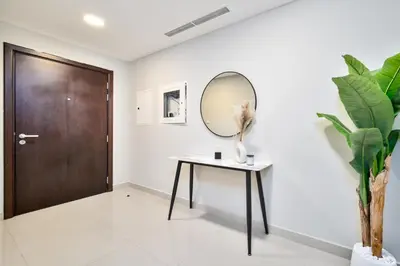 a hallway with a table and a mirror at 1BR Stunning Canal & Burj view, Luxury Stay at Fairview Residency in Dubai
