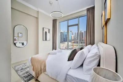 a bedroom with a large bed with a large window at 1BR Stunning Canal & Burj view, Luxury Stay at Fairview Residency in Dubai