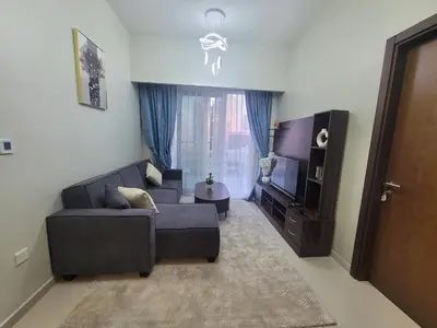 a living room with a couch and a television at Luxurious 2BHK Apartment in Reva Tower in Dubai