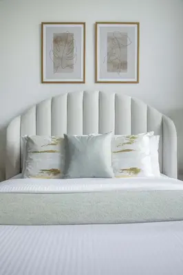 a white bed with two pillows and two pictures at Frank Porter - Samana Park Views in Dubai