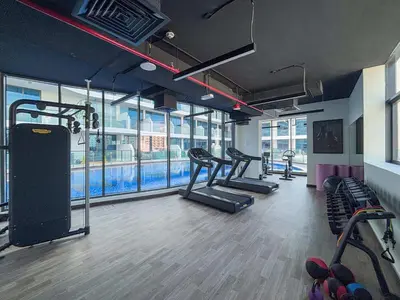a gym with several treadmills and cardio machines at Frank Porter - Samana Park Views in Dubai
