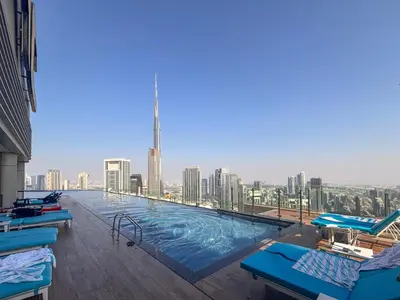 a large swimming pool with a city skyline in the background at Frank Porter - Paramount Midtown in Dubai