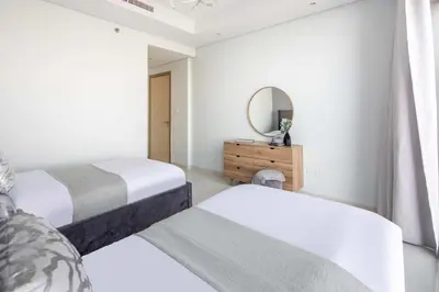 a bedroom with two beds and a mirror at Frank Porter - Paramount Midtown in Dubai