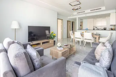 a living room with a couch and a tv at Frank Porter - Paramount Midtown in Dubai