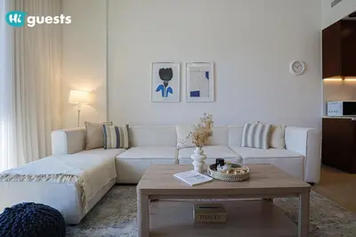 a living room with a white couch and a coffee table at HiGuests - Elegant 1BR Retreat with Sea View in La Rive in Dubai
