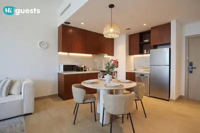 a kitchen and living room with a table and chairs at HiGuests - Elegant 1BR Retreat with Sea View in La Rive in Dubai