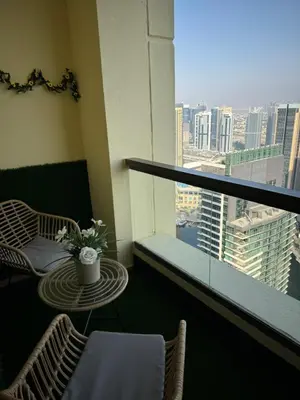 a balcony with a table and chairs and a window at Best view homes in Dubai