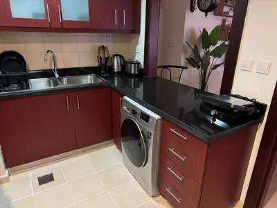 a kitchen with a sink and a washing machine at Best view homes in Dubai