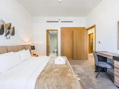 a bedroom with a large bed and a desk at Modern Retreat with Balcony and Burj Khalifa View in Dubai
