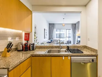 a kitchen with a sink and a living room at Modern Retreat with Balcony and Burj Khalifa View in Dubai