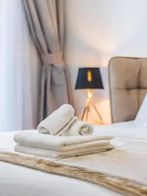 a pile of towels sitting on top of a bed at Modern Retreat with Balcony and Burj Khalifa View in Dubai