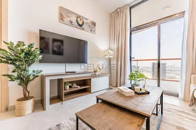 a living room with a tv and a large window at Community View 1BR with Balcony Near Downtown Dubai, Binghatti Avenue, Al Jaddaf by Deluxe Holiday Homes in Dubai
