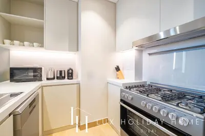 a kitchen with a stove and a microwave at LUX The La Mer Luxury Burj View Suite 3 in Dubai
