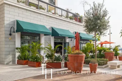 a restaurant with plants in front of a building at LUX The La Mer Luxury Burj View Suite 3 in Dubai