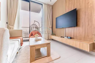 a living room with a tv on a wall at City Views 1BR with Private Balcony, Binghatti House, Jumeirah Village Circle by Deluxe Holiday Homes in Dubai
