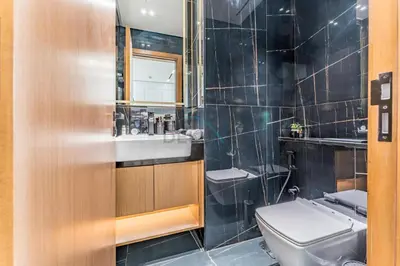 a bathroom with a toilet and a sink and a mirror at City Views 1BR with Private Balcony, Binghatti House, Jumeirah Village Circle by Deluxe Holiday Homes in Dubai