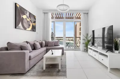 a living room with a couch and a tv at Studio Palm Views West, Palm Jumeirah in Dubai