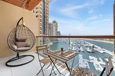 a balcony with a table and chairs and a view of a harbor at Studio Palm Views West, Palm Jumeirah in Dubai