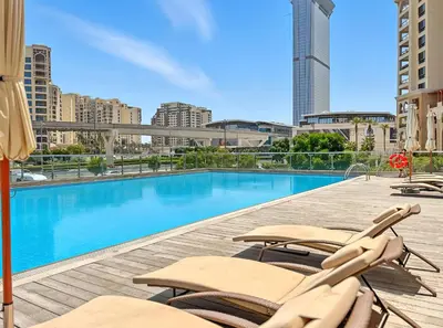 a swimming pool with chaise lounge chairs on a building at Studio Palm Views West, Palm Jumeirah in Dubai