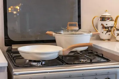 a pan sitting on top of a stove in a kitchen at Hermes-Style 2BR, Full Burj Khalifa View - Infinity Pool - Full Fountain View in Dubai