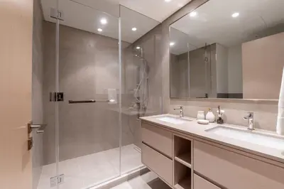 a bathroom with a shower and a sink and a mirror at Hermes-Style 2BR, Full Burj Khalifa View - Infinity Pool - Full Fountain View in Dubai