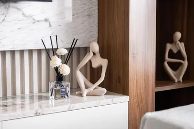 two wooden statues sitting on a counter in a room at Hermes-Style 2BR, Full Burj Khalifa View - Infinity Pool - Full Fountain View in Dubai