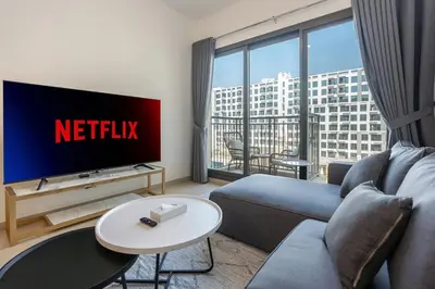 a living room with a couch and a tv with a netflix sign at Pure Voyage Town Square in Dubai