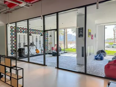 a room with sliding glass doors and a gym at Pure Voyage Town Square in Dubai