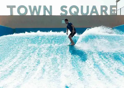 a man riding a wave in a water park at Pure Voyage Town Square in Dubai