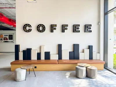 a coffee bench in a room with two stools at Pure Voyage Town Square in Dubai