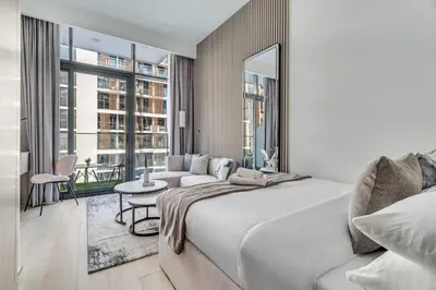 a bedroom with a large white bed and a couch at GuestReady - Riviera Studio | Burj Khalifa view in Dubai