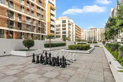 a chessboard in the middle of a courtyard with buildings at GuestReady - Riviera Studio | Burj Khalifa view in Dubai