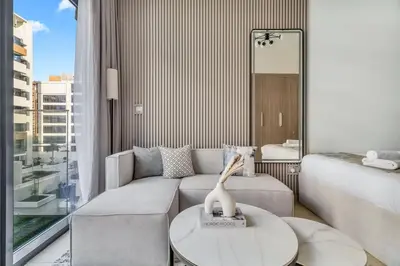 a living room with a couch and a table at GuestReady - Riviera Studio | Burj Khalifa view in Dubai