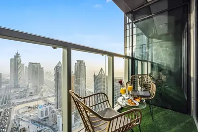 a balcony with a table and chairs and a view of the city at The Highest Infinity Pool in Downtown Dubai in Dubai