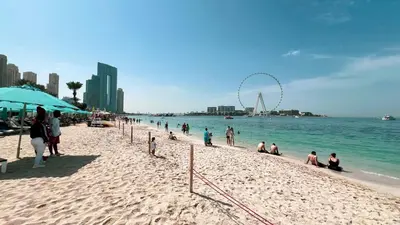 a group of people on a beach near the water at La Vie in JBR! Private Beach! Excellent Apartments! in Dubai