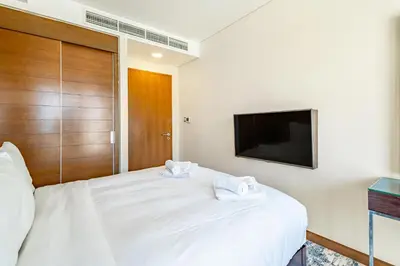 a bedroom with a white bed with a flat screen tv at SuperHost EMAAR Residences - Former Address Dubai Mall in Dubai