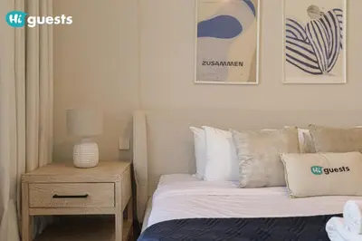 a bedroom with a bed and a side table with a lamp at HiGuest - Stylish 1BR Apartment in La Mer in Dubai